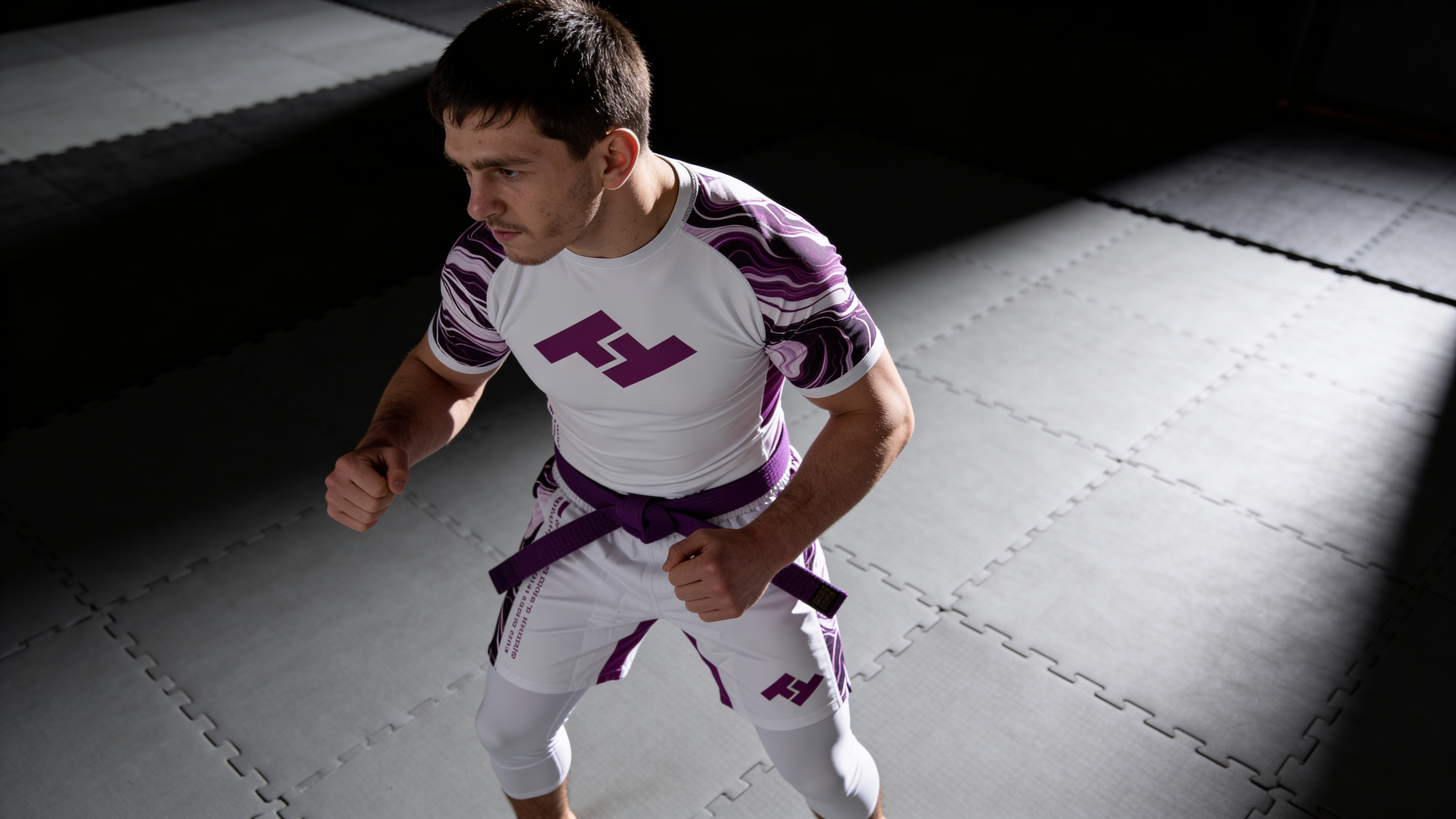 Compétiteur ceinture violette en rashguard avec accents violets Hustle Fightwear